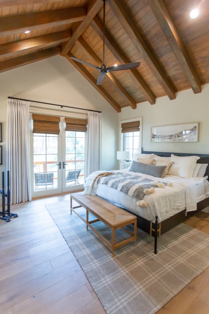 Bedroom with wood beams and striped blankets