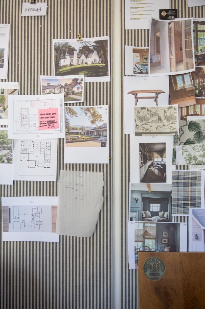 Pin board covered in plans, fabric, and photographs