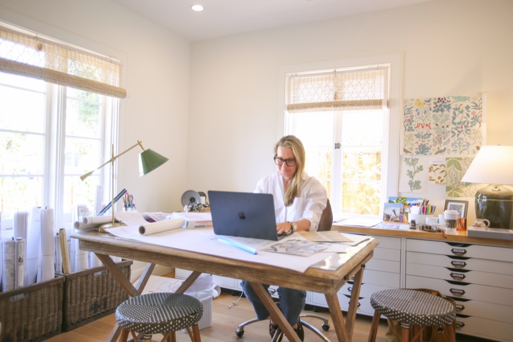 Lindsey at a drafting desk by a window