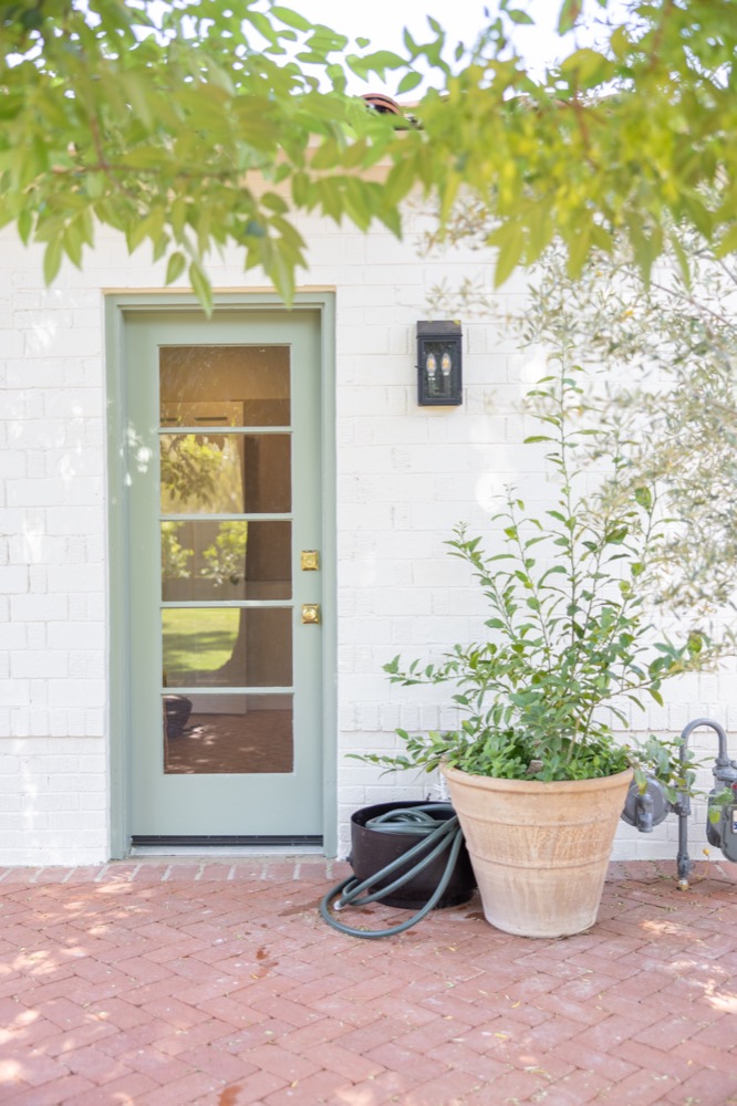 Sage door on a white brick wall, Headquarters