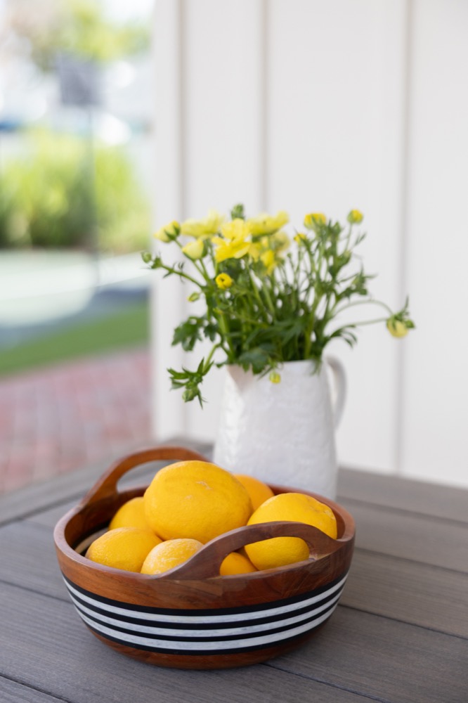 Lemons in a striped bowl on a white counter