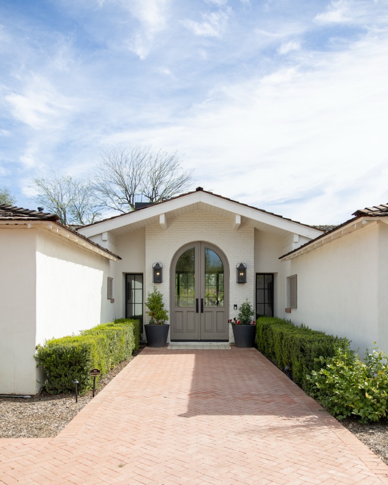 Front courtyard with brick path and arched entry