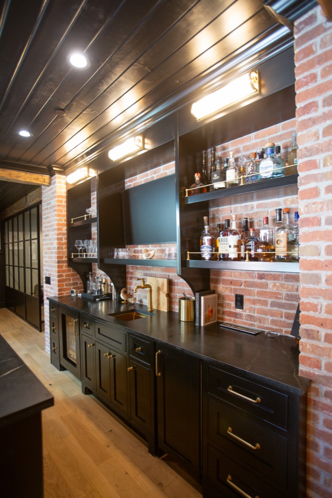 Dark bar with brick wall and brass shelves